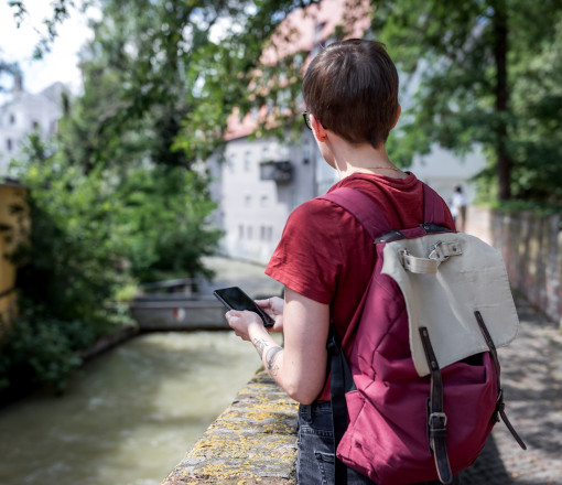 Person am Ufer eines Baches